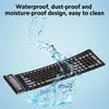 A black, flexible keyboard is shown with water splashing around it, against a light blue background. Voir les images du produit