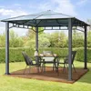A gazebo with a table and chairs set up in a garden. Produktbild-Vorschau