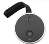 A round, black portable speaker with a silver rim and a black fabric strap attached. Voir les images du produit