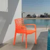 An orange plastic chair is placed on a patio next to a swimming pool, with a body of water and buildings in the background. Produktbild-Vorschau