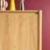 A close-up view of the top edge of a wooden sideboard with decorative items on top. Produktbild-Vorschau