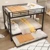A black metal bunk bed with a pull-out trundle bed, all made up with bedding in neutral tones and a yellow accent blanket. Produktbild-Vorschau