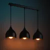 A black three-light pendant lamp hanging from a black bar against a gradient background. Produktbild-Vorschau