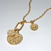 A close-up studio shot of a gold necklace with charms. Produktbild-Vorschau