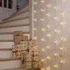 Gifts are stacked on a staircase next to a string of star-shaped lights. Podgląd zdjęcia produktu