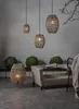 An outdoor patio scene with wicker furniture and hanging lamps. Produktbild-Vorschau