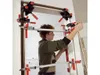 A person is using a door frame alignment tool to install a door frame. Náhled obrázku produktu