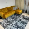 A living room scene with a yellow sectional sofa and a dark gray shaggy rug. Podgląd zdjęcia produktu