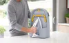 A person is holding an iron and placing it into a compact ironing board storage unit. Náhľad obrázku produktu