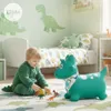 A young child plays with toy dinosaurs on a rug in a bedroom with dinosaur-themed decor. Podgląd zdjęcia produktu