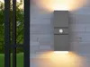 A modern gray LED wall light with a motion sensor is mounted on a textured gray and white stone wall. Anteprima dell’immagine prodotto