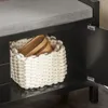 A close-up view of the interior storage compartment of a black bench with a gray upholstered seat. A white woven basket filled with wooden items is visible inside the compartment. One of the cabinet doors is open, revealing the hinges. Anteprima dell’immagine prodotto