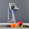 A close-up shot of a modern kitchen faucet with a digital display and LED light, with fruits in the sink below. Produktbild-Vorschau