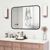 A bathroom vanity with a mirror, sinks, faucets, and various toiletries. Produktbild-Vorschau