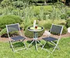 A garden table and two chairs set up in a lush garden setting. Produktbild-Vorschau