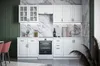 A clean, modern white kitchen setup with marble-patterned backsplash and dark green wall accent. Náhľad obrázku produktu