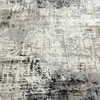 A close-up view of a textured rug with an abstract pattern. Produktbild-Vorschau