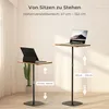 Two adjustable laptop stands are shown in a room setting, one at a lower height and one at a higher height, with text indicating height adjustment ranges. Produktbild-Vorschau