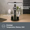A black LED desk lamp with a built-in fan and LCD display, shown on a wooden desk with pens and a laptop. Náhľad obrázku produktu
