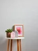 A small table with decorative items against a textured wallpaper. Produktbild-Vorschau