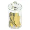A glass jar filled with dried bay leaves, presented against a white background. Voir les images du produit