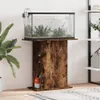 An aquarium on a wooden stand, with a plant to the left and shelves to the right. Podgląd zdjęcia produktu