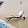 A chaise lounge chair is placed on a tiled patio next to a swimming pool. Náhľad obrázku produktu