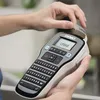 Hands holding a DYMO LabelManager 160 label maker. Produktbild-Vorschau