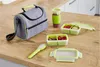 A set of Tefal lunch containers and a lunch bag are arranged on a wooden table. Voir les images du produit