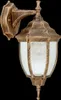 A close-up studio shot of a gold outdoor wall lamp against a black background. Produktbild-Vorschau