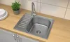 A kitchen sink with a faucet, a stack of plates, and a potted plant on a wooden countertop. Produktbild-Vorschau