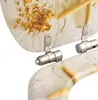 A close-up view of a toilet seat with a starfish and coral design, showing the hinges. Voir les images du produit