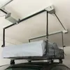 A car roof box is suspended from a ceiling-mounted lift system in a garage. Produktbild-Vorschau