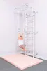 A child is playing on a metal home climbing wall with accessories in a room. Voir les images du produit