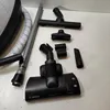 Various vacuum cleaner attachments laid out on a light gray surface. Anteprima dell’immagine prodotto