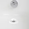 A close-up view of a white bathtub with a chrome overflow drain cover and a white silicone drain stopper and hair catcher. Voir les images du produit
