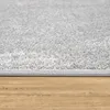 A close-up view of a gray rug with a textured surface, placed on a wooden floor. Anteprima dell’immagine prodotto
