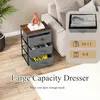 A KOMFOTTEU dresser with three drawers is placed next to a sofa, with a plant in the background. The image also includes graphics indicating clothing capacity. Podgląd zdjęcia produktu