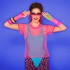 A woman wearing a neon pink mesh top and leopard print leggings, posing against a blue background. Produktbild-Vorschau