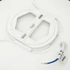 A white plastic spool with a cable attached to it, lying on a white surface. Produktbild-Vorschau