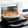 A hand is shown removing a pizza from a white oven on a black countertop. Produktbild-Vorschau