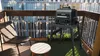 A grill on a balcony with a chair and table. Voir les images du produit