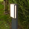 A modern outdoor LED path light is shown in a garden setting, surrounded by lush green foliage. Anteprima dell’immagine prodotto
