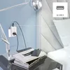 A smart plug is shown plugged into a wall outlet, powering a lamp and charging a device on a nightstand next to a bed. Náhľad obrázku produktu
