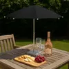 A table setting with a mini umbrella, wine, cheese, crackers, and grapes on a wooden table outdoors. Voir les images du produit