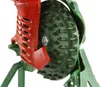 A close-up view of a mechanical corn sheller, showing its red and green cast iron components and the spiked shelling wheel. Náhled obrázku produktu
