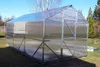 A greenhouse is set up in a grassy yard on a sunny day. Anteprima dell’immagine prodotto