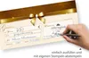 A hand is shown filling out a gift certificate with a pen. Produktbild-Vorschau