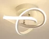 A modern white LED ceiling light fixture with a swirling design, mounted on a white ceiling.