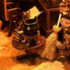 A miniature scene depicting a witch's cauldron and broomstick, part of a DIY book nook kit. Voir les images du produit